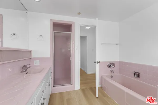 a bathroom with a tub sink and mirror