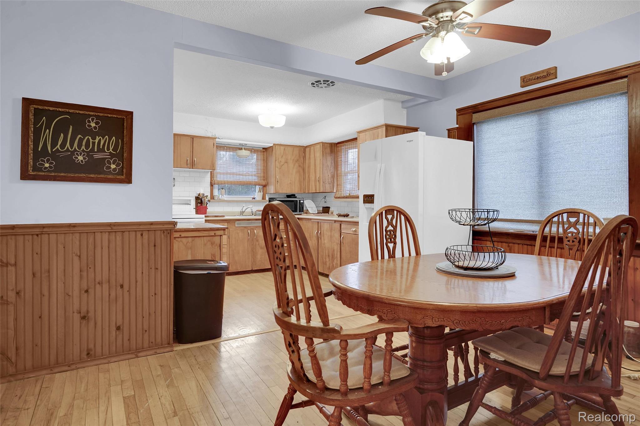 7972 3rd Street Forestville, MI 48434 - Photo 9 of 35 Dining space with light wood-style floors, a ceiling fan, and wainscoting