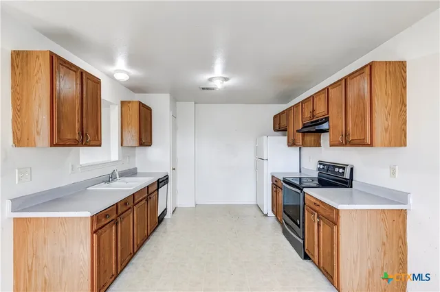 a kitchen with stainless steel appliances a sink stove and cabinets