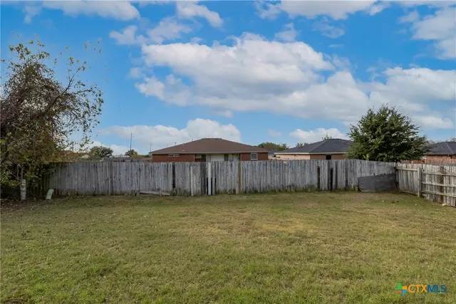 a view of a backyard with wooden fence