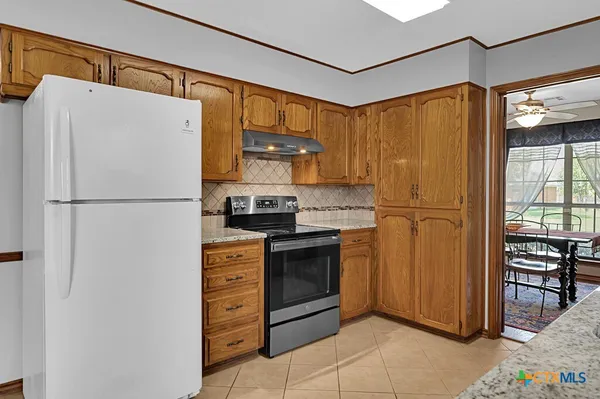 a kitchen with stainless steel appliances granite countertop a refrigerator and a stove