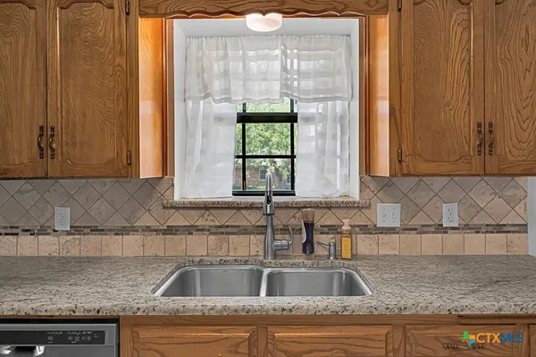 a kitchen with granite countertop a sink and a window