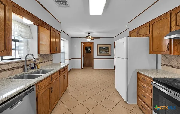 a kitchen with granite countertop a refrigerator and a sink