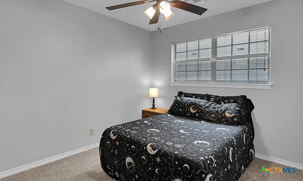 a bed sitting in a bedroom next to a window