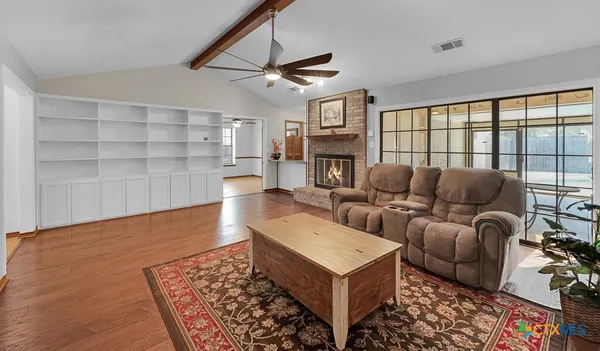 a living room with furniture a fireplace and a large window