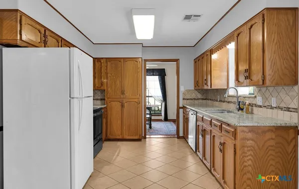 a kitchen with stainless steel appliances granite countertop a refrigerator and a sink