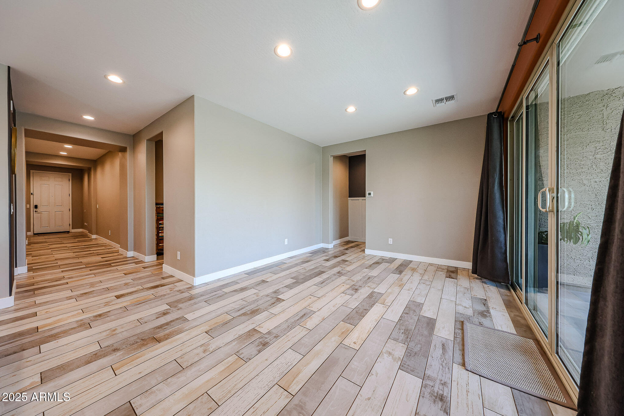 3907 South 75th Drive Phoenix, AZ 85043 - Photo 29 of 49 a view of an empty room with wooden floor and a window