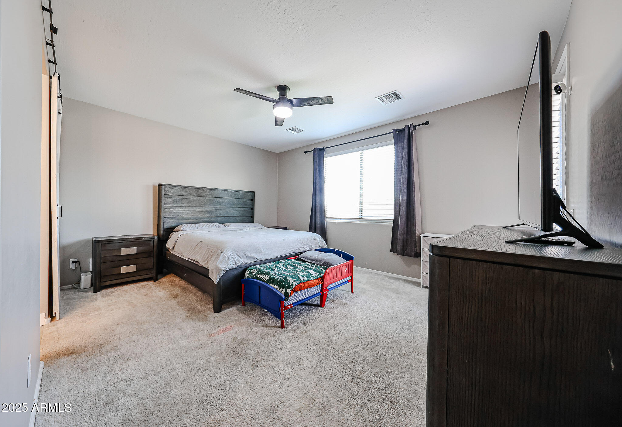 3907 South 75th Drive Phoenix, AZ 85043 - Photo 34 of 49 a bedroom with a bed and a chandelier