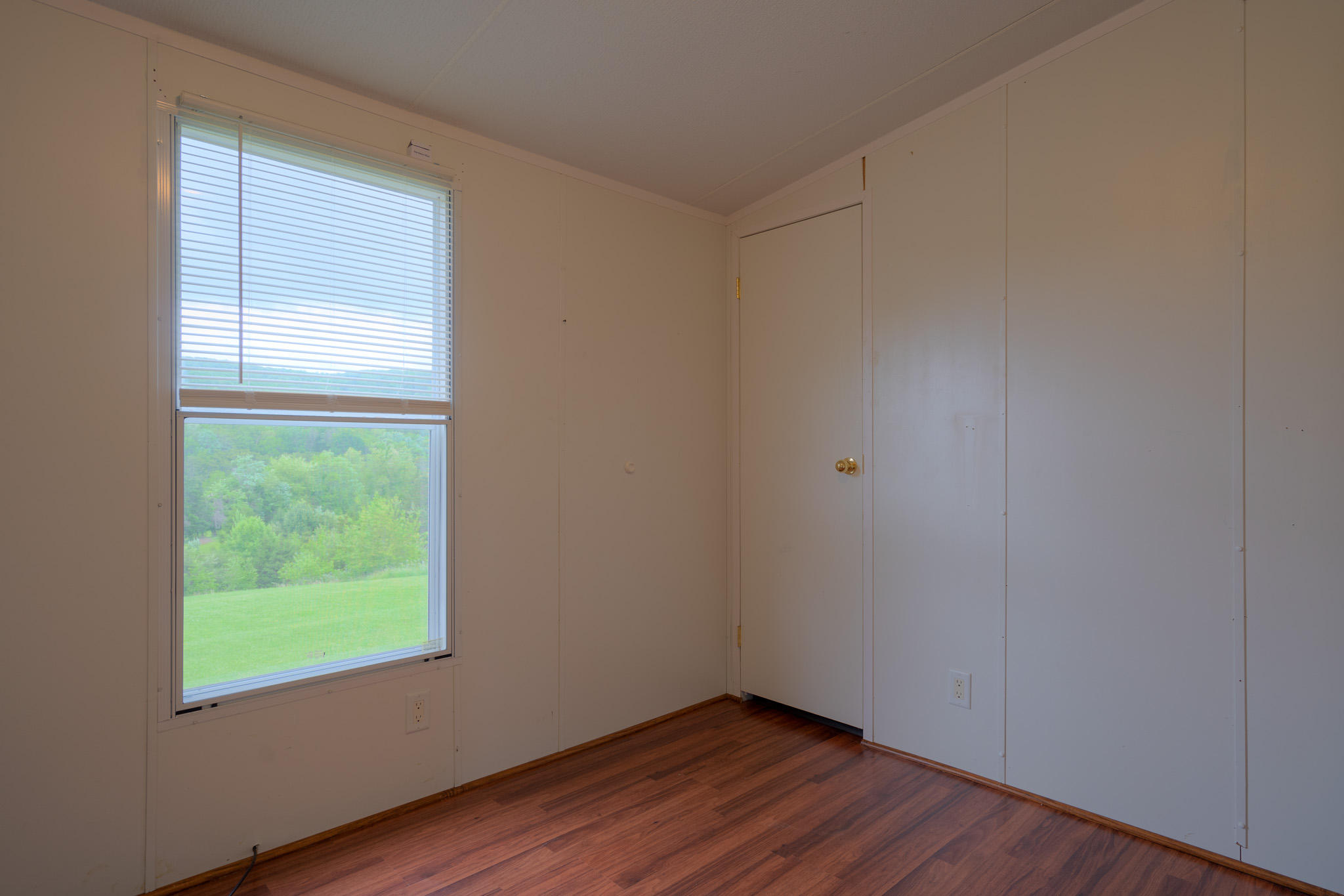 3240 Dallas Freeman Road Hiwassee, VA 24347 - Photo 16 of 42 a view of an empty room with wooden floor and a window
