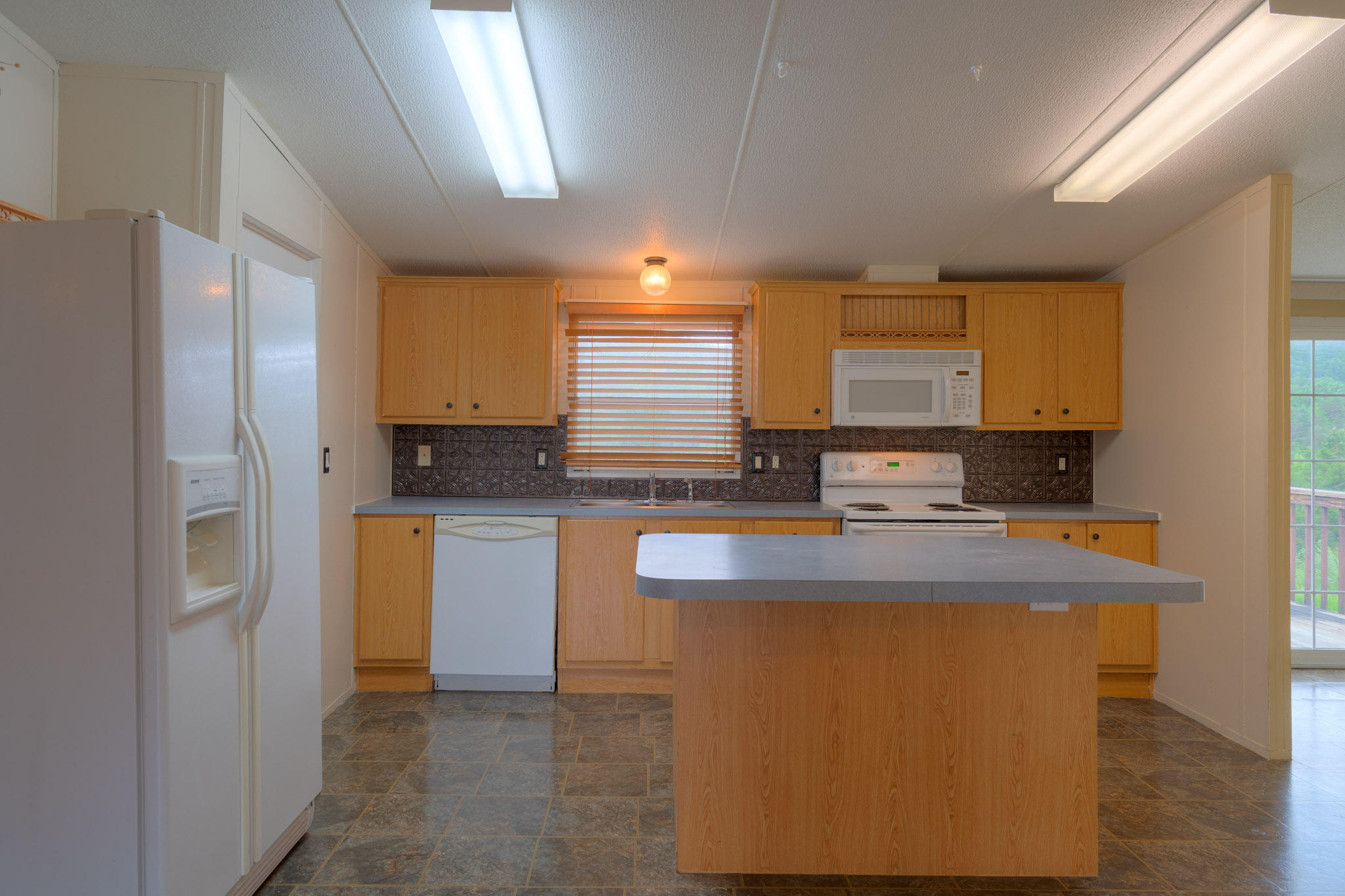 3240 Dallas Freeman Road Hiwassee, VA 24347 - Photo 7 of 42 a kitchen with stainless steel appliances granite countertop a sink a stove a refrigerator a center island and a window