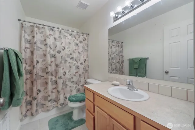 a bathroom with a granite countertop sink a toilet and a mirror