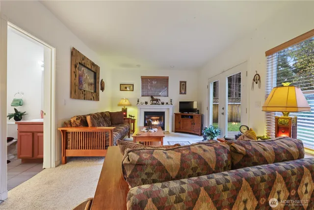 a living room with furniture a fireplace and a large window