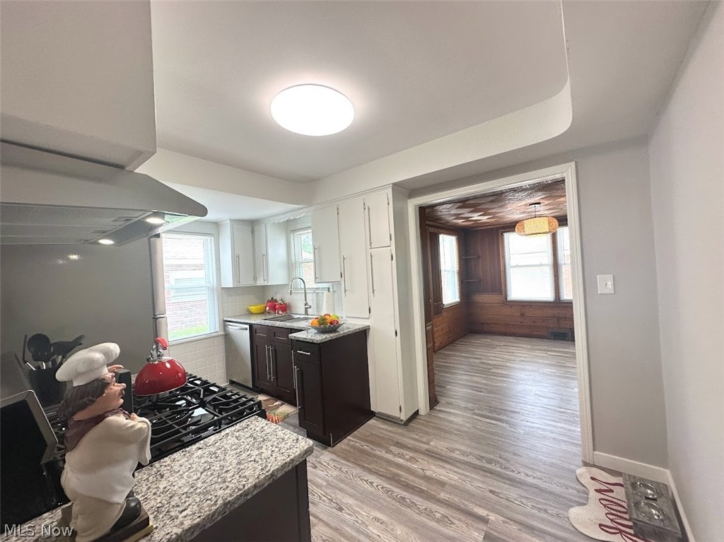 4227 Eastway Road South Euclid, OH 44121 - Photo 5 of 18 Kitchen with white cabinetry, wall chimney range hood, sink, dishwasher, and light hardwood / wood-style floors