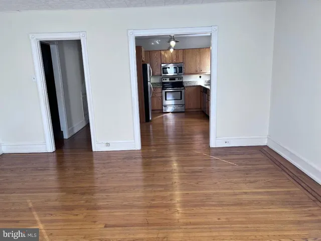 a view of a living room and kitchen with a wooden floor