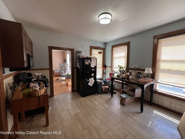 a view of living room with stainless steel appliances furniture a rug and a flat screen tv