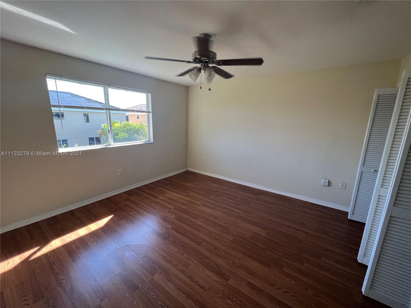 20441 Northwest 15th Avenue, Unit 8 Miami Gardens, FL 33169 - Photo 13 of 30 an empty room with wooden floor and windows
