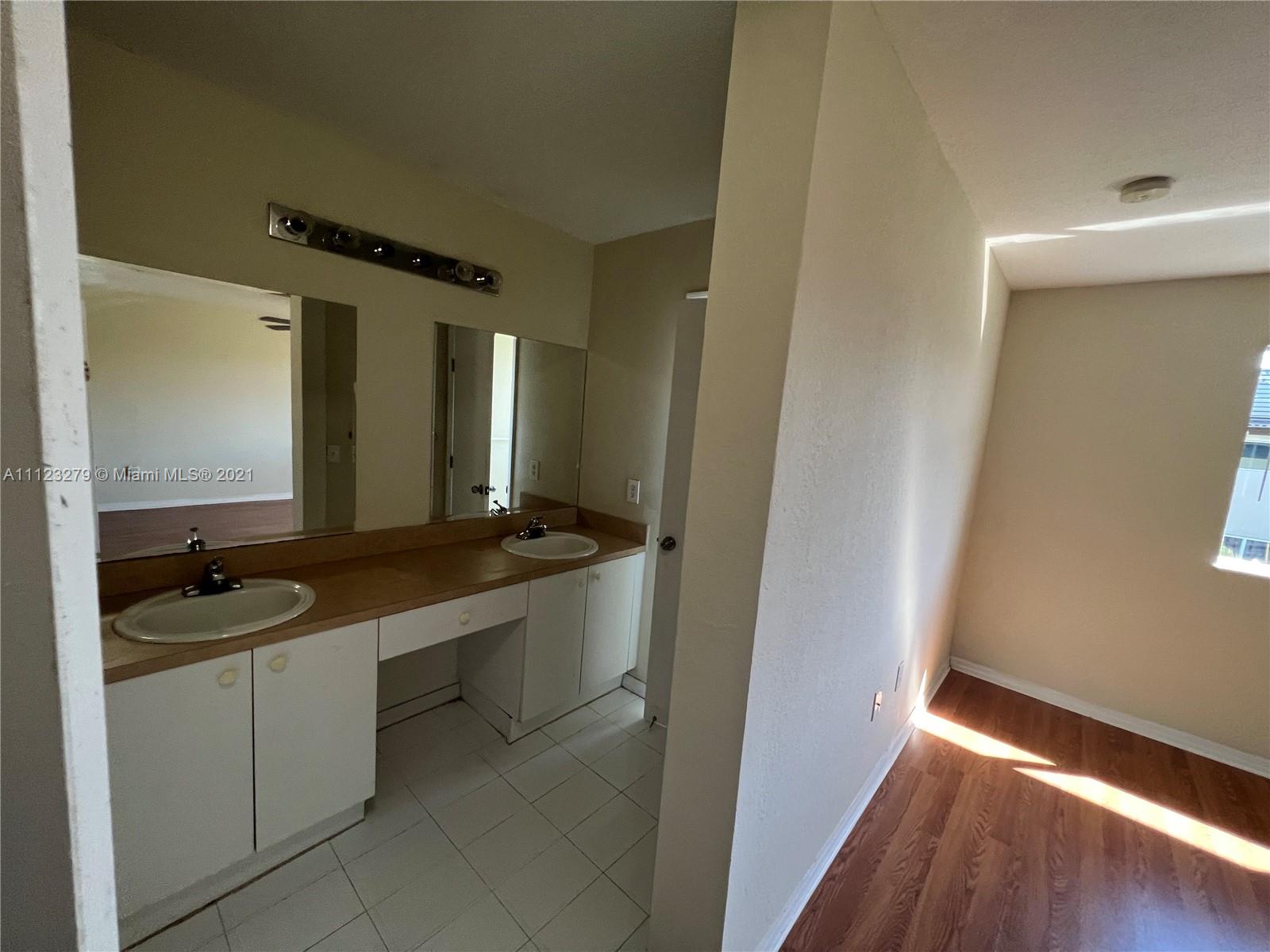 20441 Northwest 15th Avenue, Unit 8 Miami Gardens, FL 33169 - Photo 21 of 30 a bathroom with a granite countertop sink a mirror and a