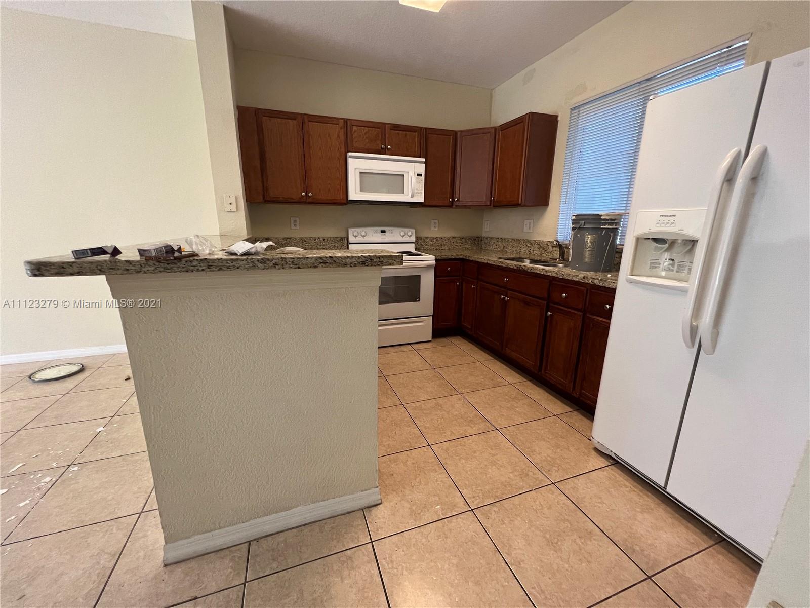 20441 Northwest 15th Avenue, Unit 8 Miami Gardens, FL 33169 - Photo 27 of 30 a kitchen with stainless steel appliances granite countertop a refrigerator stove and a sink