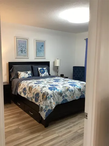 a bedroom with a bed and painting on the wall