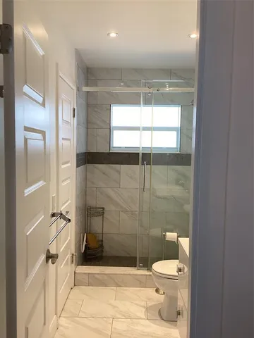 a bathroom with a toilet and a shower