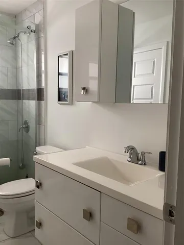 a bathroom with a sink a toilet and a mirror