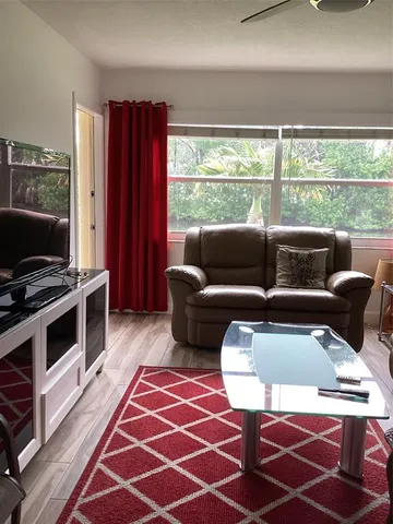 a living room with furniture and a floor to ceiling window