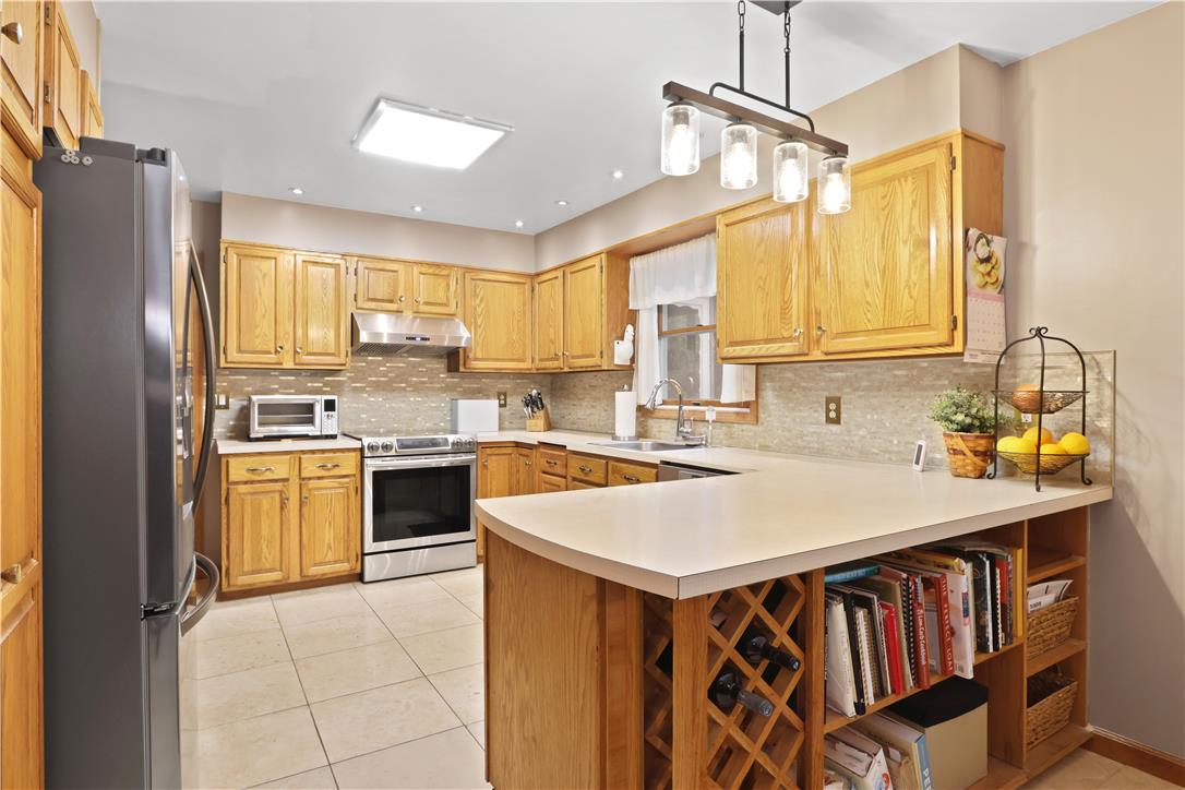 209 Remington Road East Stroudsburg, PA 18301 - Photo 12 of 41 A warm kitchen features ample wood cabinetry, light countertops, and modern appliances.