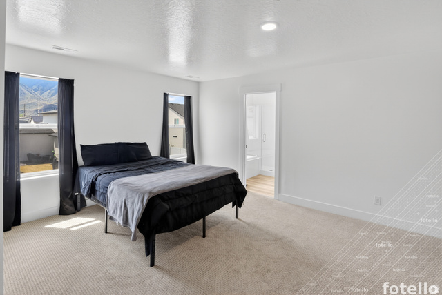 815 West Powderwood Lane Mapleton, UT 84664 - Photo 19 of 39 Bedroom featuring light carpet, a textured ceiling, and connected bathroom