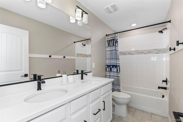 a bathroom with a granite countertop sink a toilet a mirror and shower