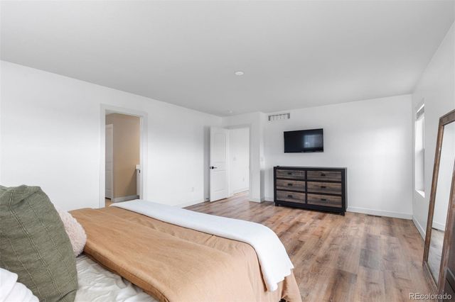 a bedroom with a bed and wooden floor