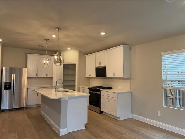 a large kitchen with stainless steel appliances kitchen island a large counter top and a sink
