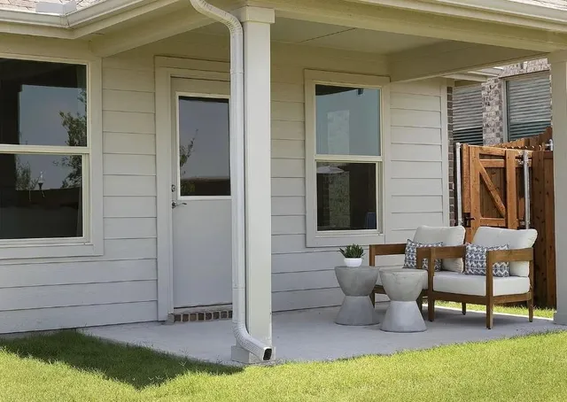 a kitchen with stainless steel appliances a sink a stove a refrigerator cabinets and a dining table