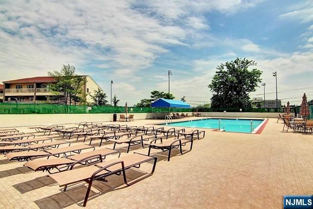 1203 River Road, Unit 19K Edgewater, NJ 07020 - Photo 17 of 19 a view of swimming pool with outdoor seating and yard in back