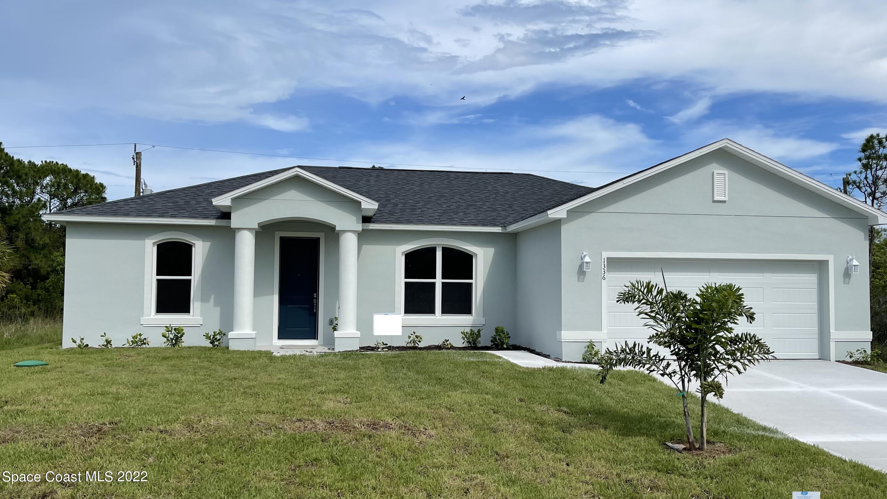 1336 Rabbit Street Southeast Palm Bay, FL 32909 - Photo 1 of 16 front view of the house with a yard