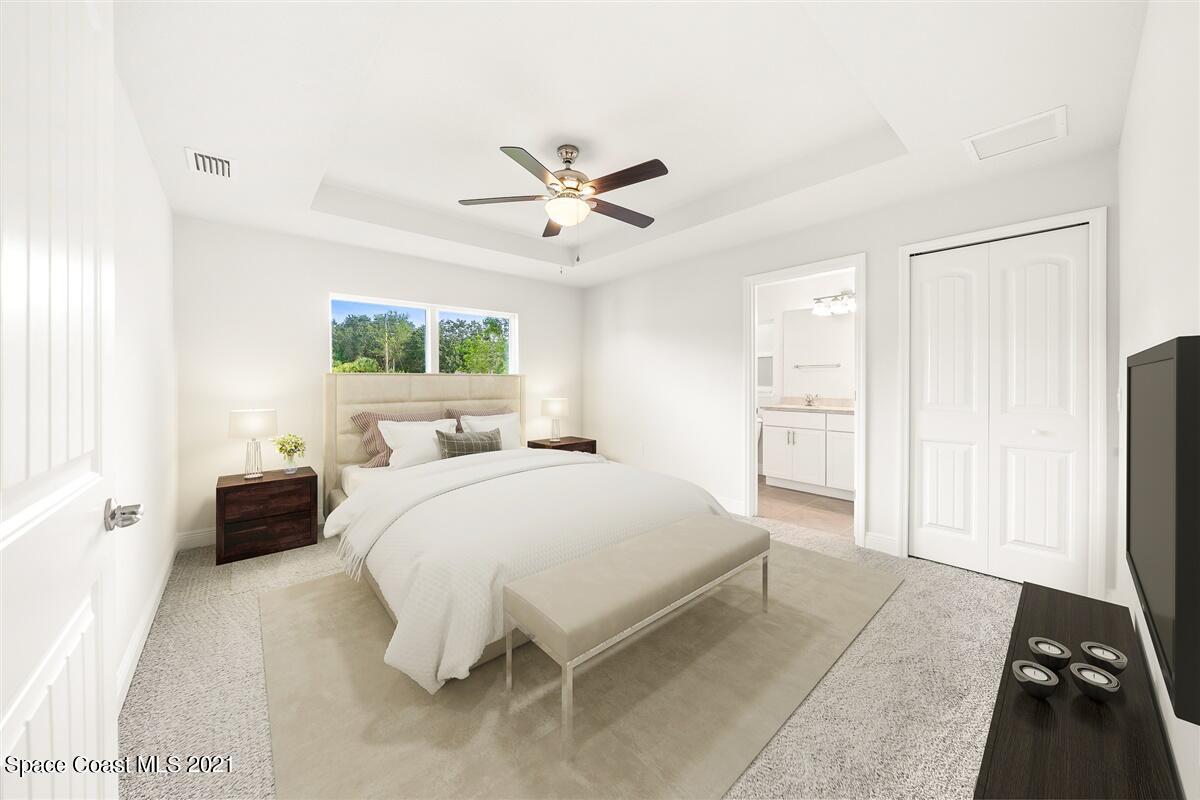 1336 Rabbit Street Southeast Palm Bay, FL 32909 - Photo 3 of 16 a spacious bedroom with a bed and a chandelier