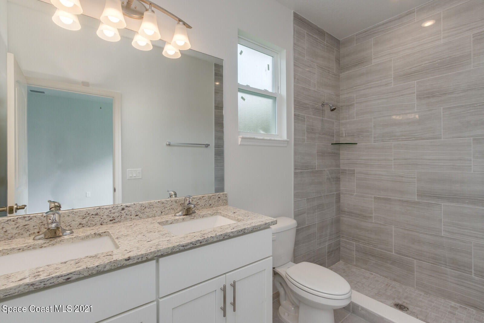 1336 Rabbit Street Southeast Palm Bay, FL 32909 - Photo 8 of 16 a bathroom with a granite countertop sink a toilet and shower