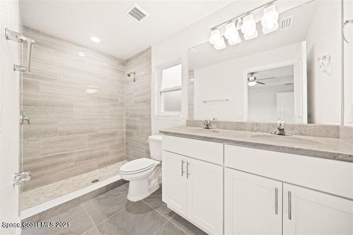 1336 Rabbit Street Southeast Palm Bay, FL 32909 - Photo 9 of 16 a bathroom with a granite countertop sink toilet and shower