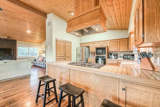 a view of a house with a yard and a large tree