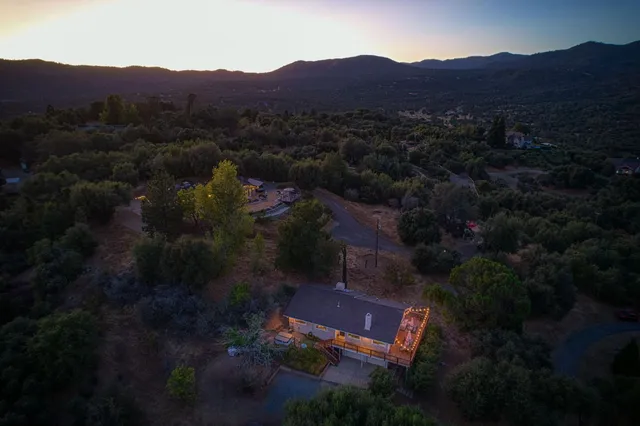 a aerial view of a house with a yard basket ball court and outdoor seating