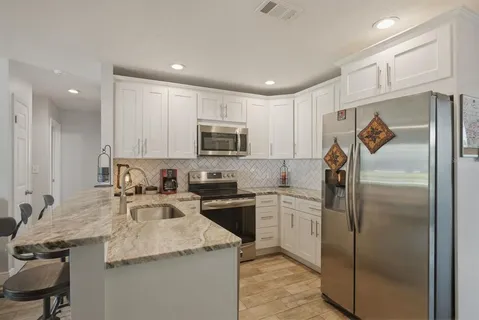 a kitchen with a sink appliances and cabinets