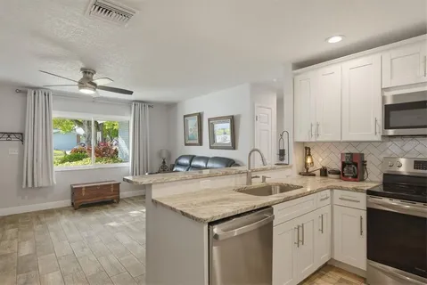 a kitchen with granite countertop a sink a stove and cabinets