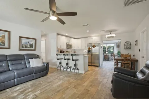 a living room with furniture and kitchen view