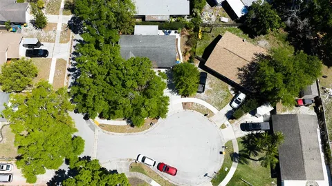 an aerial view of a house with swimming pool and garden