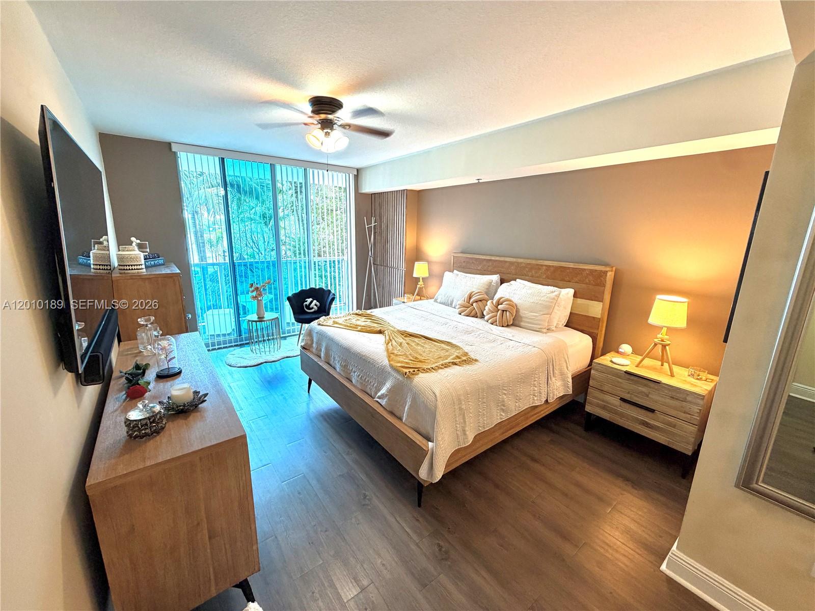2641 North Flamingo Road, Unit TH4N Sunrise, FL 33323 - Photo 23 of 30 a bedroom with a bed window and a flat screen tv