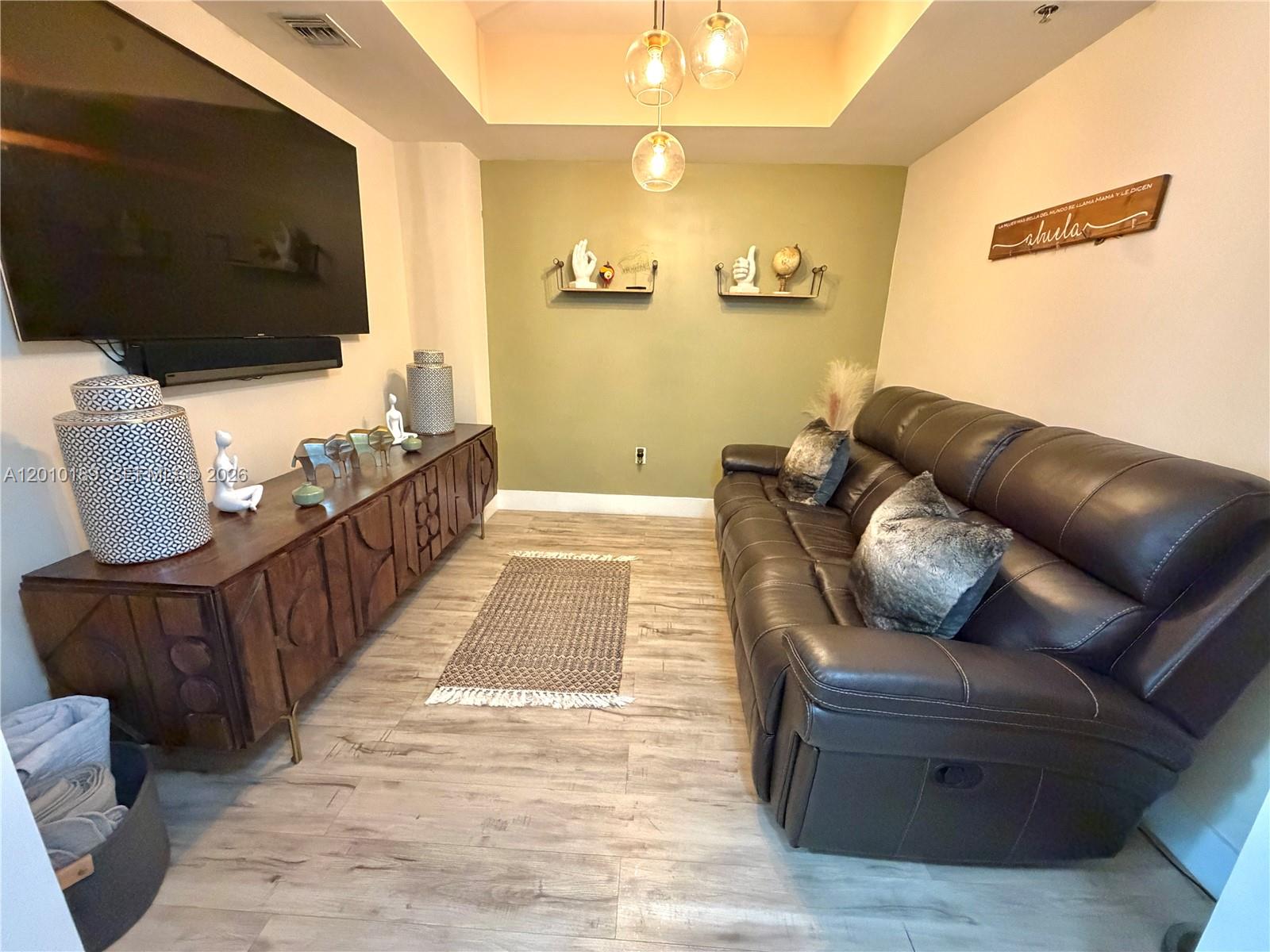 2641 North Flamingo Road, Unit TH4N Sunrise, FL 33323 - Photo 8 of 30 a living room with couches bookshelf and a flat screen tv