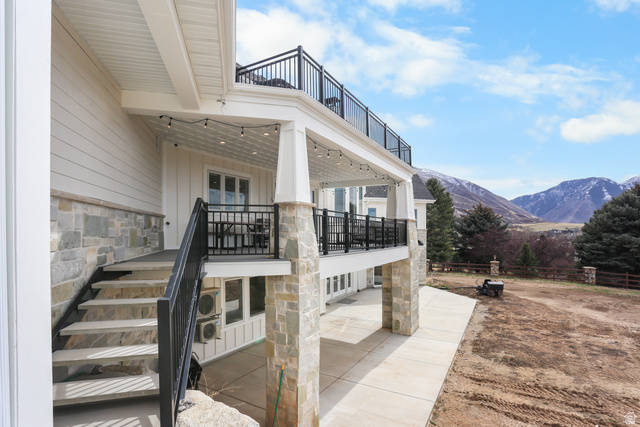 1354 South 800 East Mapleton, UT 84664 - Photo 107 of 129 View of side of home with stone siding, a mountain view, a patio area, and a balcony