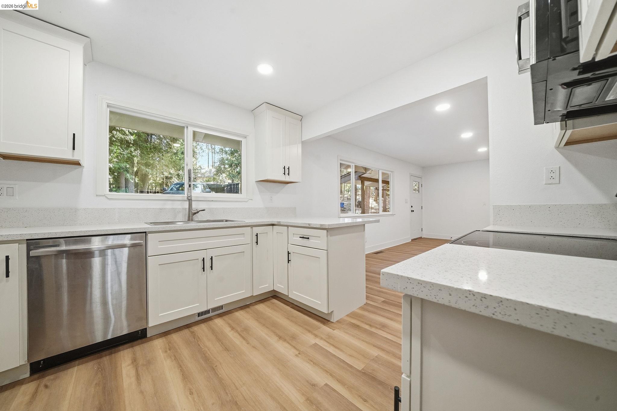 23656 Lightning Pioneer, CA 95666 - Photo 13 of 23 Kitchen featuring light wood-type flooring, dishwasher, light stone counters, recessed lighting, and white cabinets