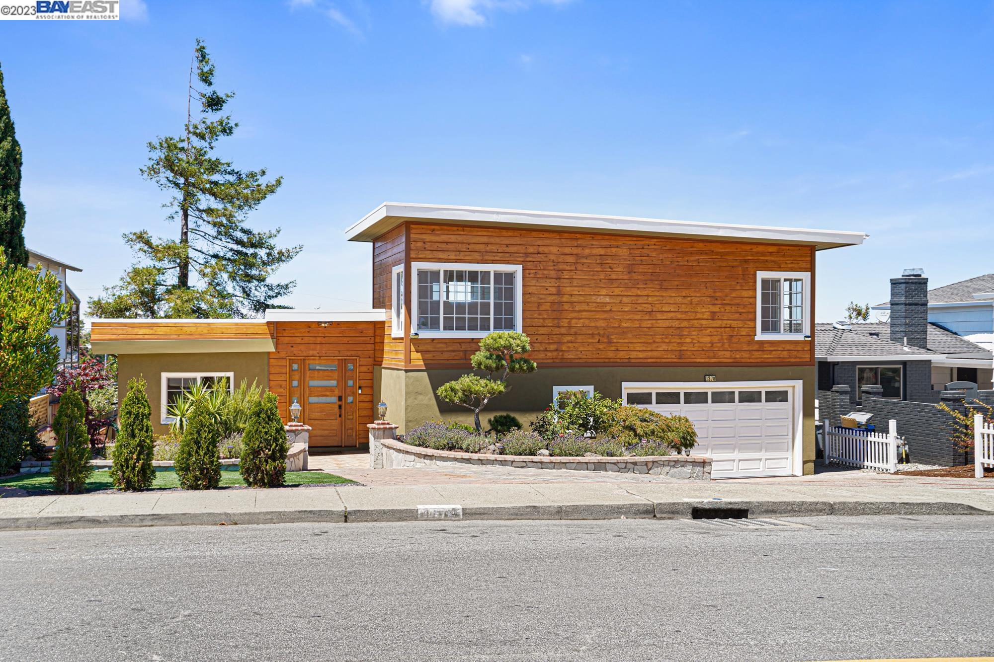 a front view of a house with a garden and plants