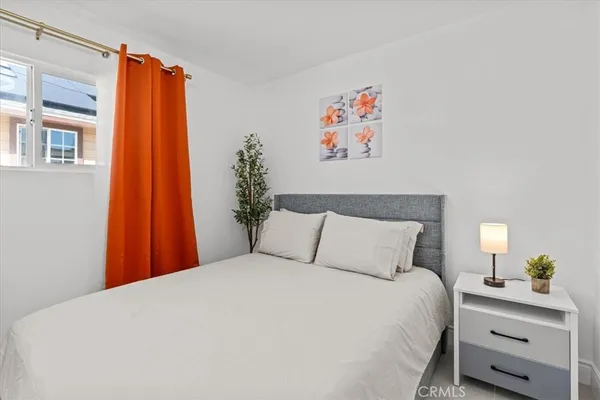 a large bed in a bedroom next to a window