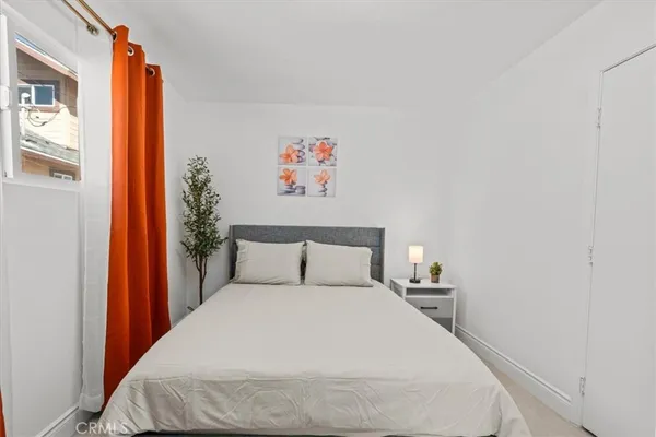 a bedroom with a bed and a painting on the wall